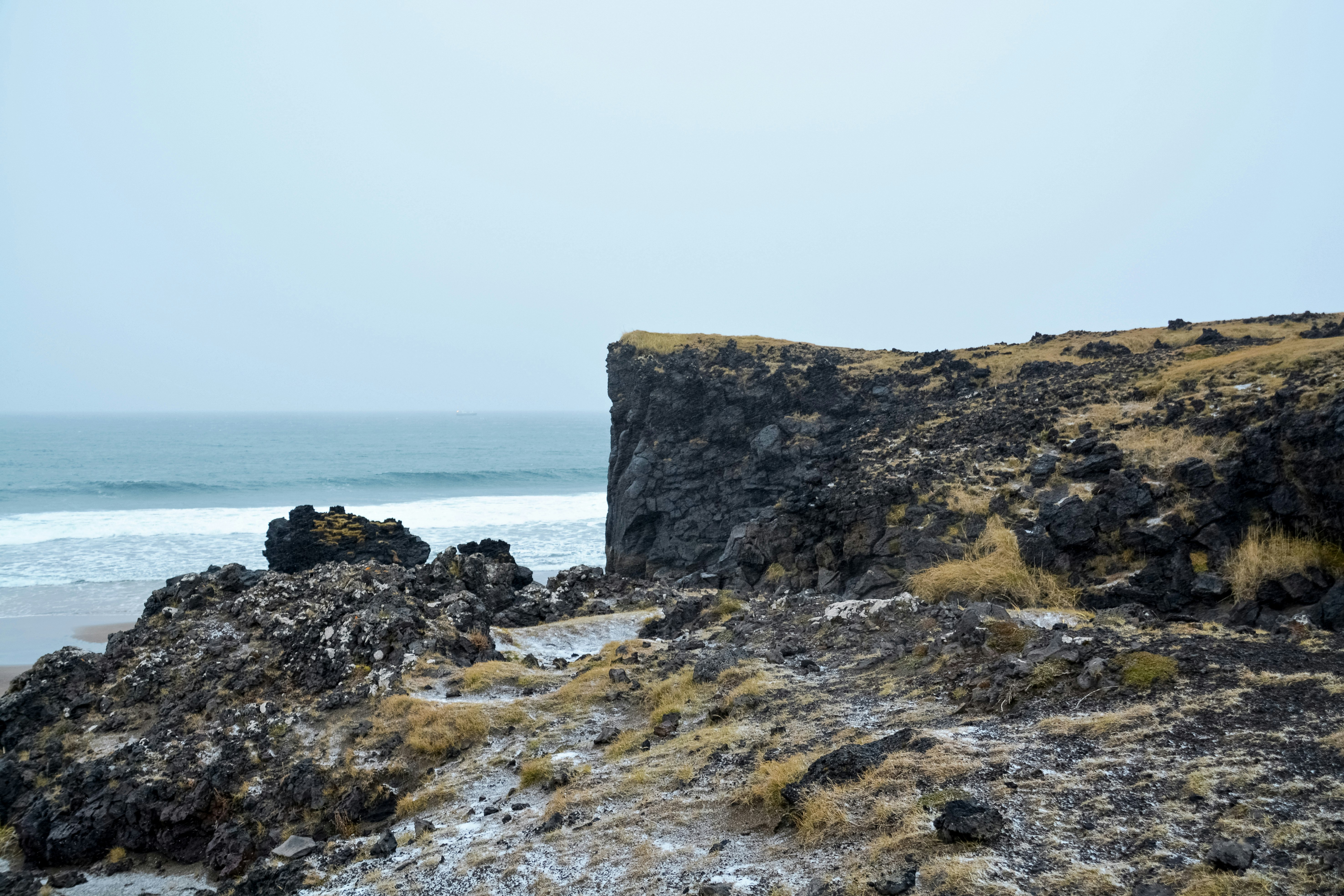 brown rock formation near body of water during daytime